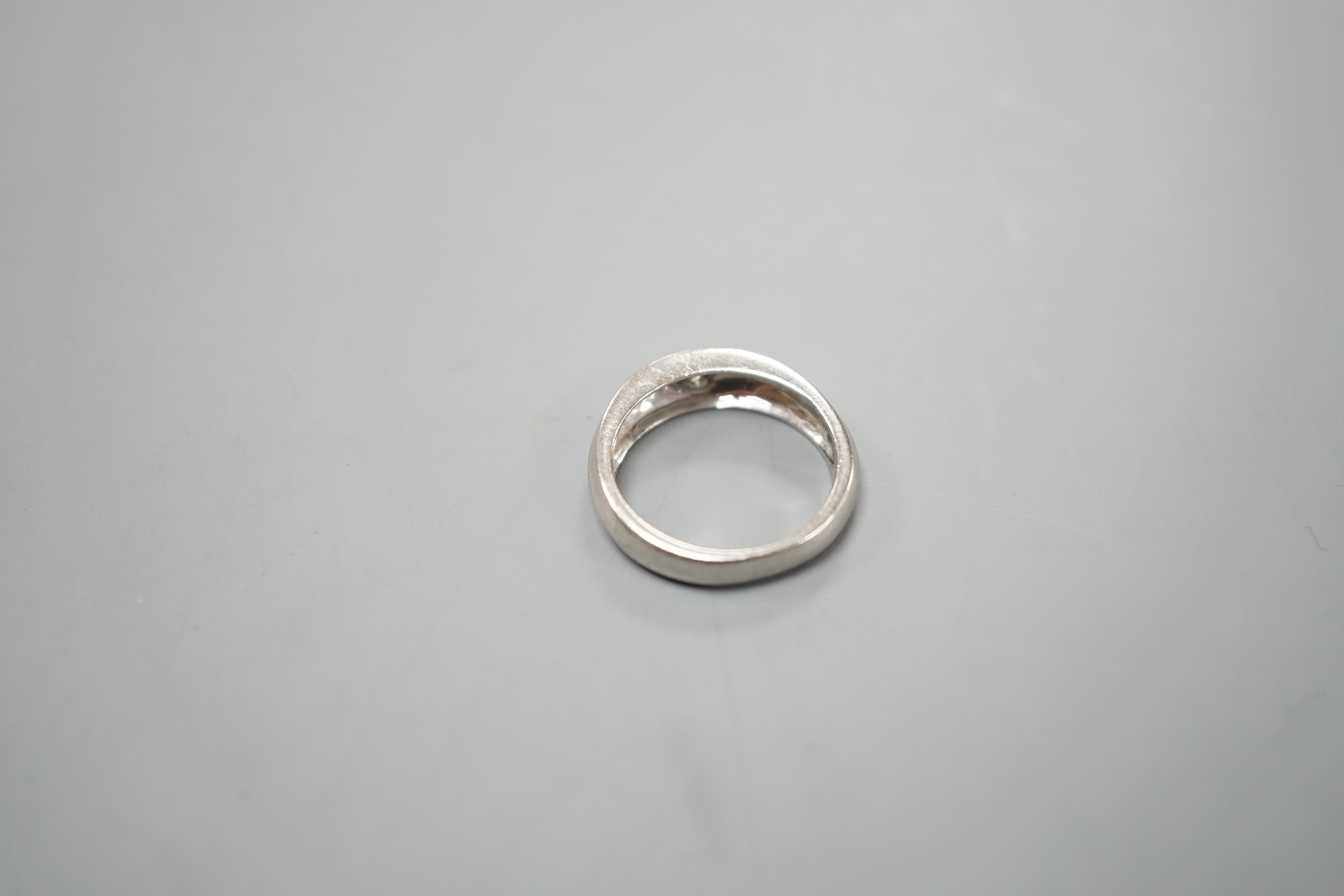 A modern platinum and gypsy set solitaire diamond ring, size K, 6.6 grams.
